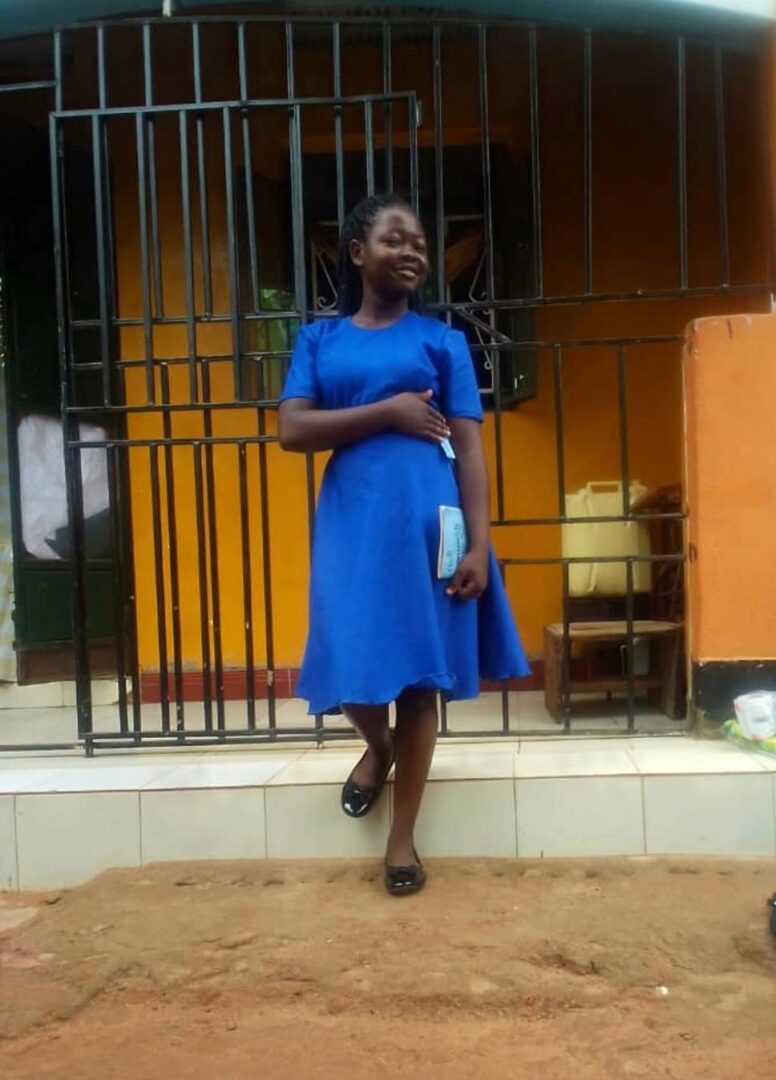 A woman in blue dress standing on steps.