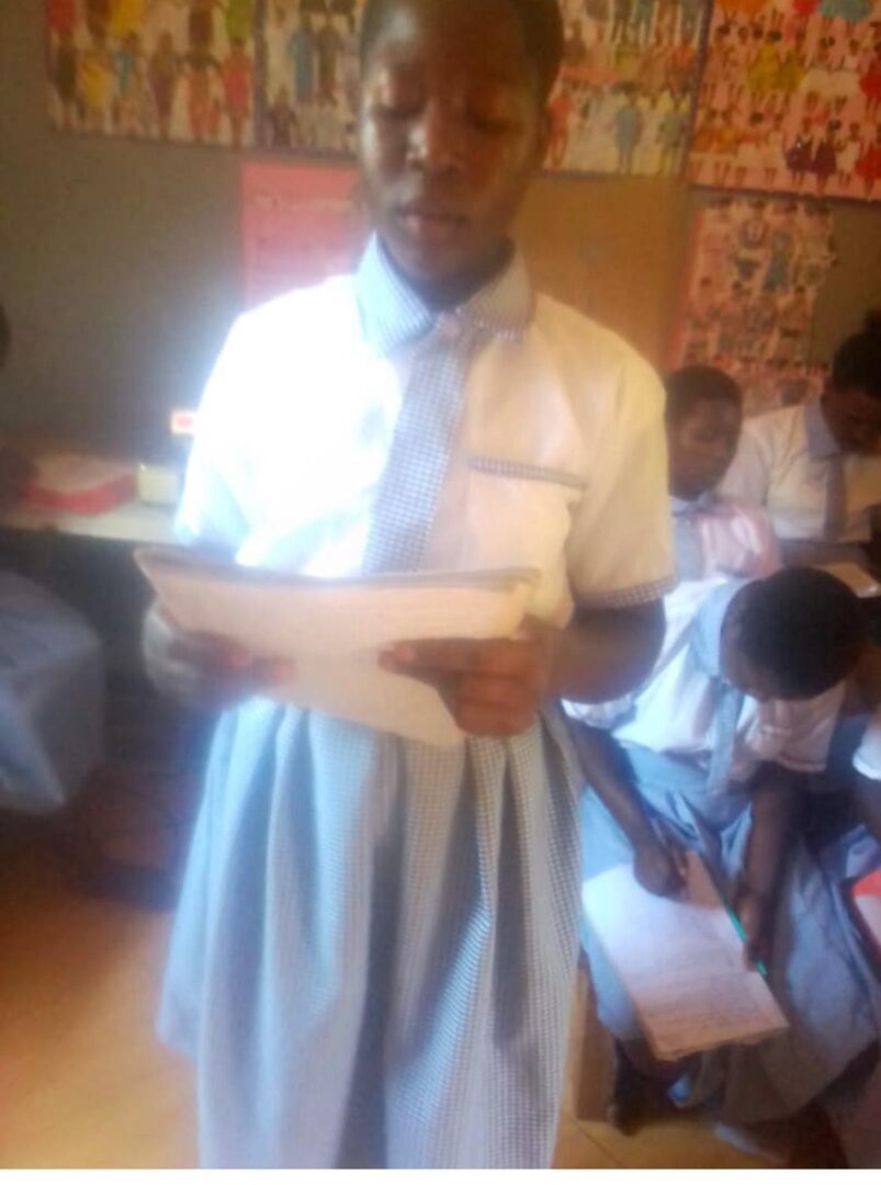 A man in a dress shirt and tie holding papers.