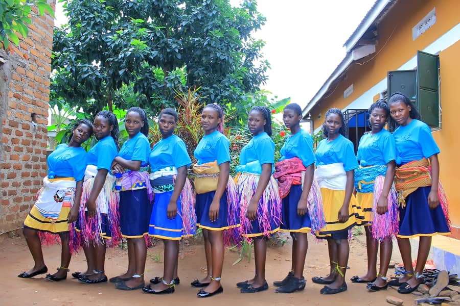 A group of young girls in blue shirts and skirts.