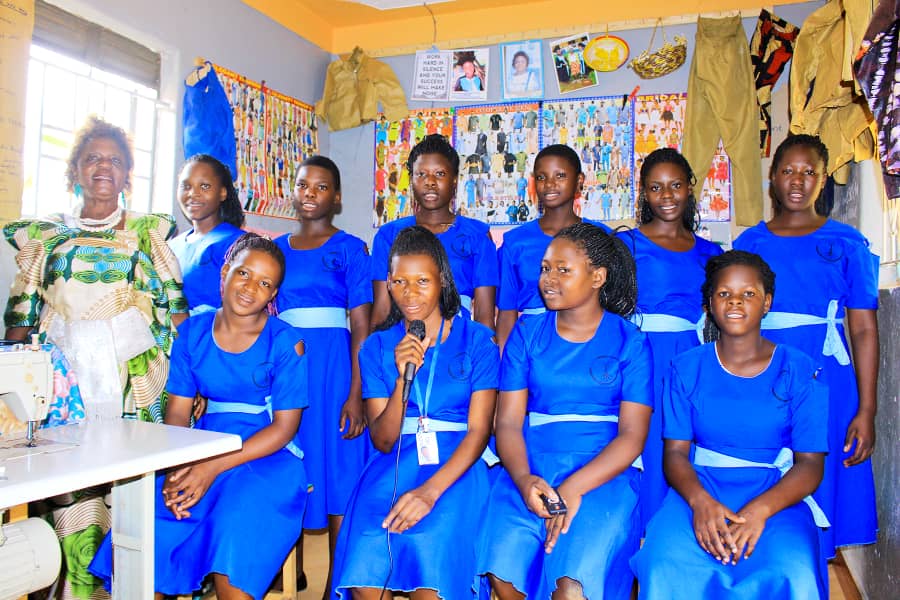 A group of women in blue dresses posing for the camera.