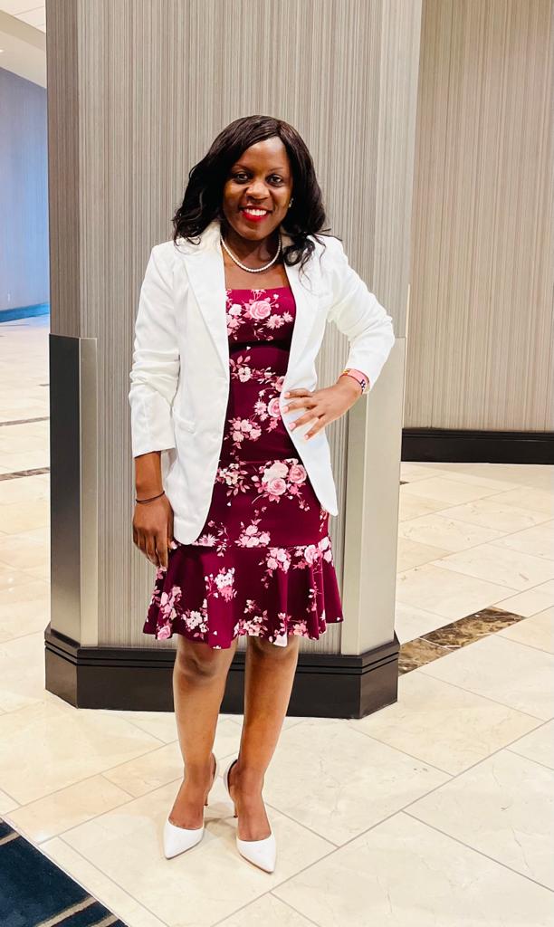 A woman in a white jacket and floral dress.